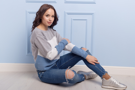 beautiful cute girl with a smile demonstrates knitted clothesの写真素材