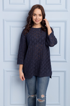 beautiful cute girl with a smile demonstrates knitted clothesの写真素材