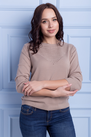 beautiful cute girl with a smile demonstrates knitted clothesの写真素材