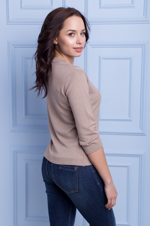 beautiful cute girl with a smile demonstrates knitted clothesの写真素材