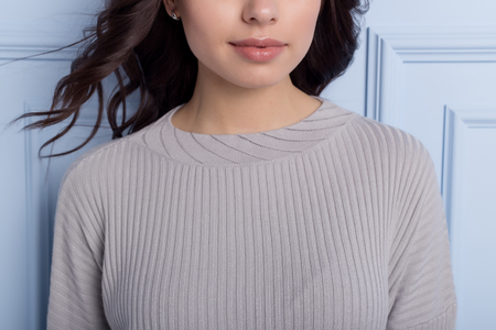 beautiful cute girl with a smile demonstrates knitted clothesの写真素材
