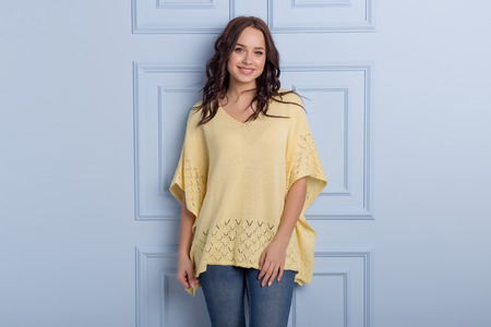 beautiful cute girl with a smile demonstrates knitted clothesの写真素材