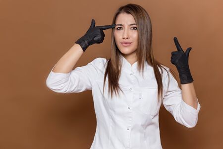 girl medical worker in black gloves in a white suit with a magazine in her handsの写真素材