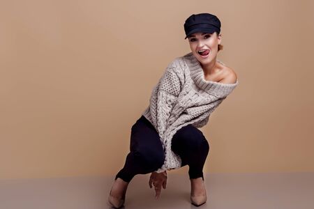 beautiful girl with glasses in a black cap on a beige backgroundの写真素材
