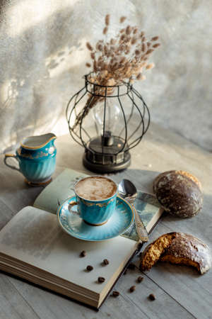 beautiful vintage cup of coffee with milk and gingerbread on the tableの写真素材