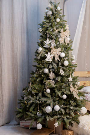 beautiful green christmas tree decoration with toys and ribbonsの写真素材