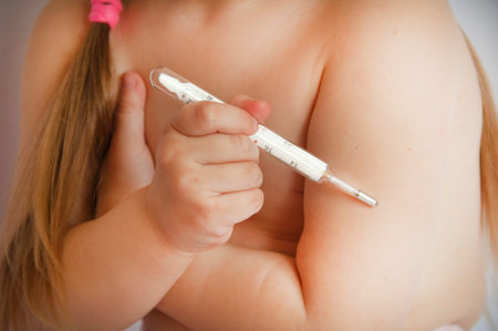 child and thermometer. girl measures the temperature with a thermometer. girl with a thermometer.の写真素材