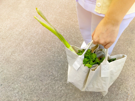 Young women use recyclable bags to shop for vegetables in the fresh market in the morning to reduce...