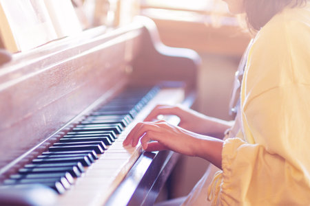 A woman playing piano in her roomの写真素材