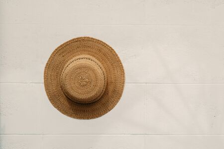 Straw hat on white wall texture backgroundの写真素材