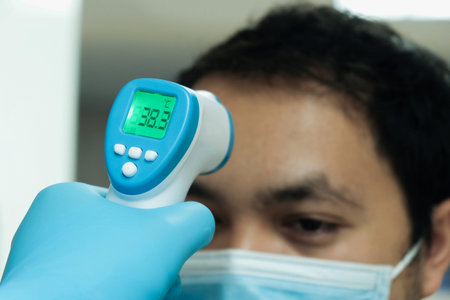 Medical staff use infrared forehead thermometer for check body temperature, Covid-19 outbreak...