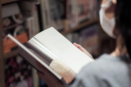 Asian women and surgical mask in bookstores, covid-19 crisis, new normal lifestyleの写真素材