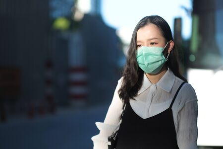 Asian women wear surgical face masks to protect The Covid-19 in public areasの写真素材