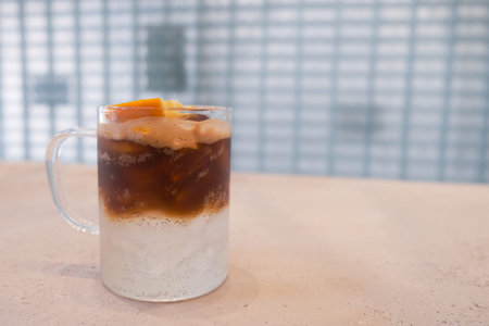 A glass of ice black coffee and orange juice 