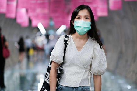 Asian girl wear surgical mask to protect the Covid-19 virus in public areas, New normal lifestyleの写真素材