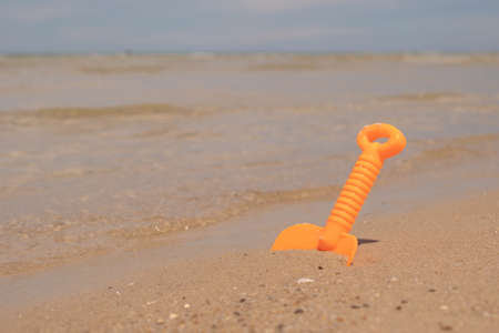 Orange plastic toy on the beachの写真素材