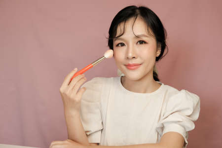 Asian girl beauty blogger with makeup brushの写真素材