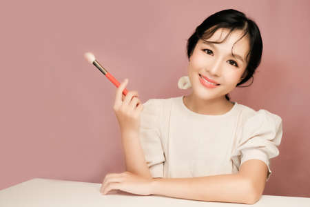 Asian girl beauty blogger with makeup brushの写真素材