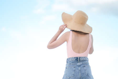 Asian woman with pink swimsuit and Straw hat on the beachの写真素材