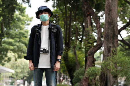 Asian travelers man in the forest with medical face mask to protection the   new normal lifestyleの写真素材