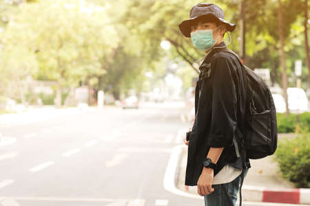 Asian travelers man in the street with medical face mask to protection the , new normal lifestyleの写真素材