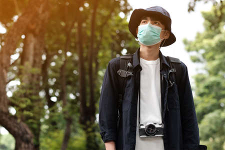 Asian travelers man in the forest with medical face mask to protection the   new normal lifestyleの写真素材