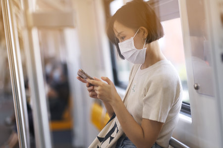 Asian women wear surgical mask in the train station, New normal lifestyleの写真素材