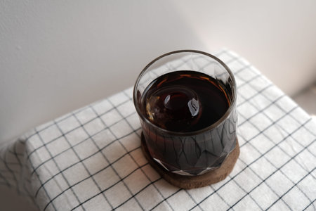 A glass of iced black coffee on wood plate