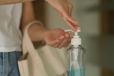 A girl using alcohol gel for cleaning handsの写真素材