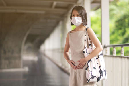 Asian pregnant woman with medical face mask to protect the Covid-19, new normal lifestyleの写真素材