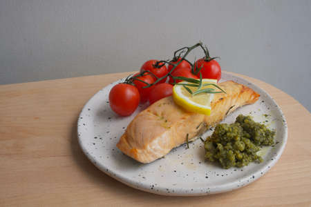 Salmon steak on white plate in restaurantの写真素材