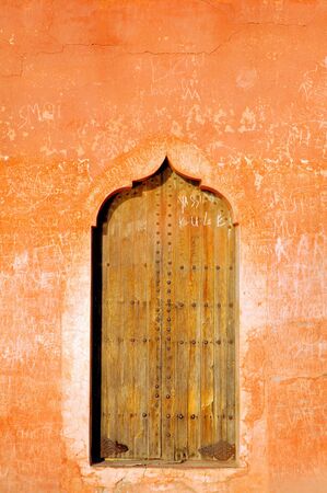 Morocco, Marrakech, Marrakesh: Menara garden; red and white walls framed a typical wood doorの写真素材
