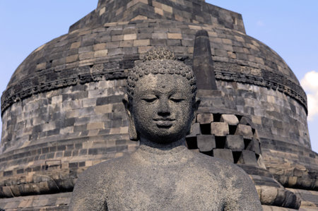 Indonesia, java, Borobudur: a beautifull stone seat buddha in meditation facing to the  sunrise at the most famous asiatic temple, the bigest buddhist temple from the first millenium in the world の写真素材