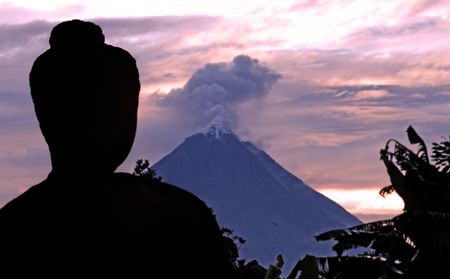 Indonesia, java, Borobudur: Merapi Volcano at the sunrise, Indonesia, java, Borobudur: a beautifull stone seat buddha in meditation facing to the  sunrise at the most famous asiatic temple, the bigest buddhist temple from the first millenium in the world の写真素材