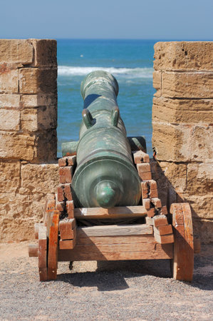 Morocco, Essaouira: blue sky, blue water and a very old bronze cannon in a fortress