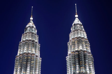 malaysia kuala lumpur the twin towers of petronas at the city center illuminated at the beginning of the nightのeditorial素材