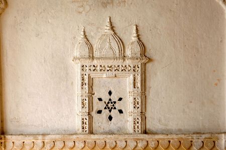 India, Rajasthan, Jaisalmer: Sculpture on the wall in Jaisalmer's fort; white wall decorated with a small carved architectureの写真素材