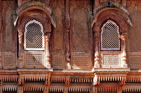 India, Jaisalmer: Indian palace architecture; red walls and wooden carved frame and windowsの写真素材
