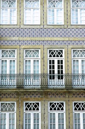 Portugal, Porto: Facade; typical portuguese facade from the 19th or begining of the 20th century; blue ceramics and a line of windows and doorsの写真素材
