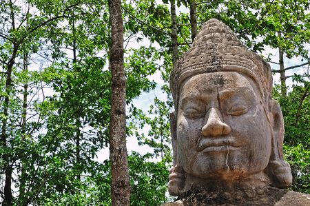 In Cambodia view of an old sculpted khmer head in the ancient city of Angkorの写真素材