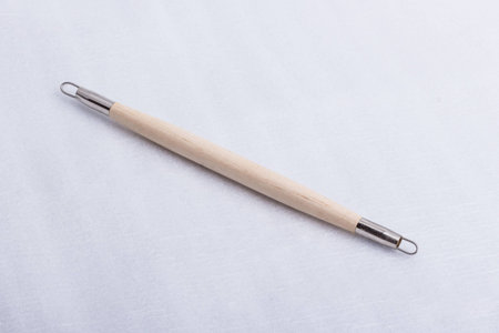 A sculpting tool made out of wood and steel on a white surface.の写真素材
