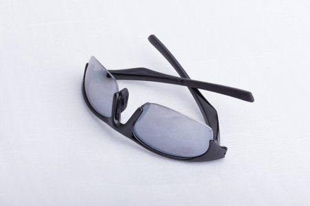 A pair of black, athletic sun glasses on a white surface.