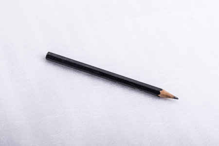 A black used pencil, on a white surface.の写真素材