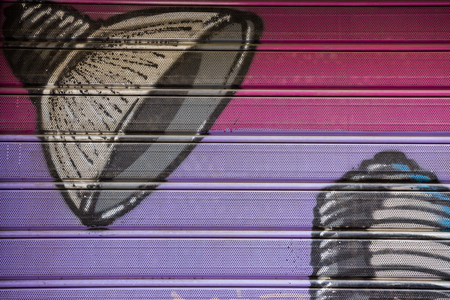 A graffiti on a store's metal shutter depicting a lamp-hat.の写真素材