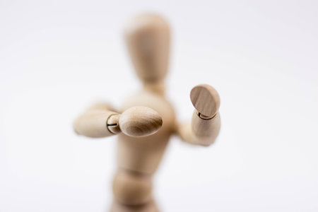 The upper body of a wooden mannequin in a boxing position, in front of a white background.の写真素材