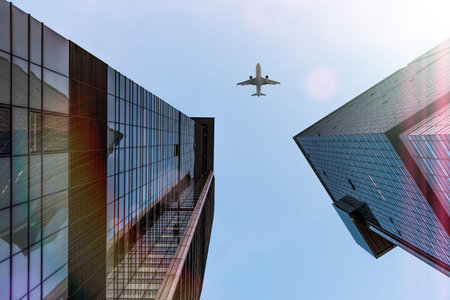 Low angle shot of buildings and airplane flying over