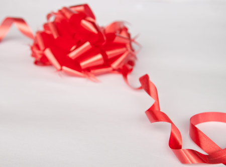 Shiny red satin ribbon on whiteの写真素材