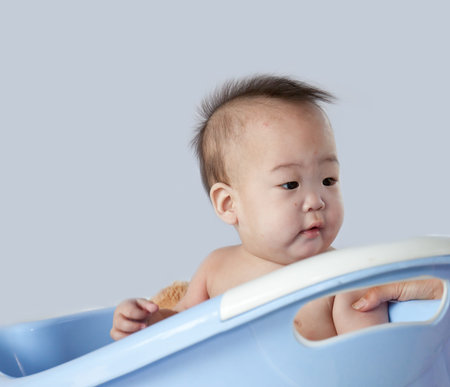 Cute baby having bath in blue tub