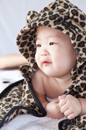 a beautiful smiling baby wrapped in a furry tiger skinの写真素材