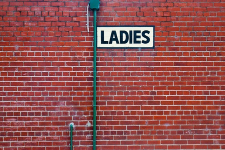 Black toilet sign on the orange wallの写真素材